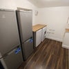 Photo 9: A separate utility room contains two fridge/freezers, a washer/dryer and additional storage.