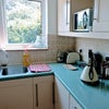 Photo 4: Bright aqua kitchen with gas hob