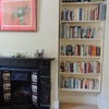 Photo 3: Original tiled fireplace and huge bookshelf in room