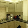 Photo 1: Kitchen area - showing sink and washing machine
