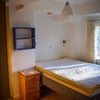 Photo 4: There's a smart TV mounted on the wall opposite the bed