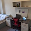 Photo 2: The room is furnished with desk, drawer, chair, bed, closet, and shelf