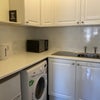 Photo 3: Utility room, tennants own sink cupboards, kettle, Microwave, air fryer, fridge. 