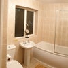 Photo 4: Second bathroom with full-size bath, overhead shower, and plenty of shelf space