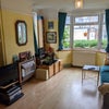 Photo 3: Living room with large bay window and smart TV and extensive DVD collection