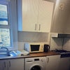 Photo 4: The kitchen area with toaster, microwave  and fridge .