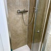 Photo 11: Modern shower with easy clean splashwall & chrome fittings.