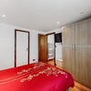 Photo 14: Bedroom 1 - desk, dressing table with illuminated mirror, double bed, and ample storage