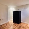 Photo 8: This black set of drawers is the only furniture the room was furnished with, but I may be able to ge