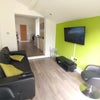 Photo 7: The lounge includes a widescreen television, sofa and chairs.