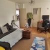 Photo 7: View of the living room from the balcony corner. The bedroom door is the one to the left of the desk