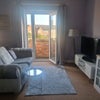 Photo 3: Living room area with comfortable sofa, tv, small table and lamp