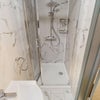 Photo 7: Compact shower room with marble-effect walls.
