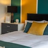 Photo 8: Crisp bedding, soft lighting and a bold feature wall