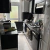 Photo 5: Kitchen with large fridge freezer, gas stove, over, washing machine. Door leads to garden.