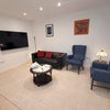 Photo 3: Spacious living area / 65'' TV / Sofa / Table / Chairs