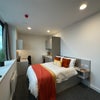 Photo 6: Studio Bedroom example, with bed, kitchenette, desk, cupboard and ensuite