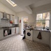 Photo 5: The kitchen, has two fridges, gas stove and a washing machine