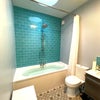 Photo 4: Large bathroom with double basin unit with drawers and lit mirrors above, bath with shower, toilet.